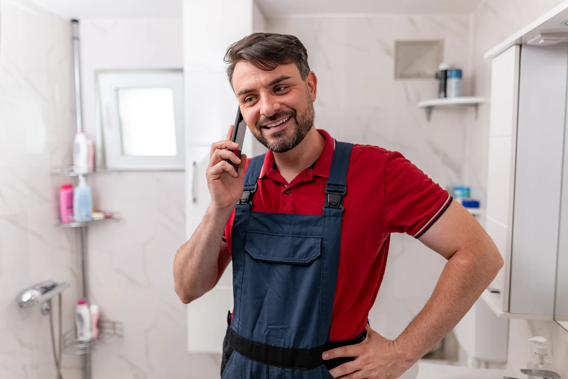 Smiling plumber answering a customer phone call